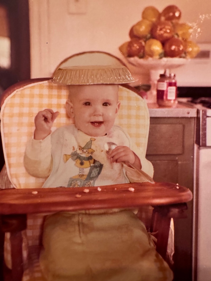 Bizza as a baby wearing a pie tin for a hat